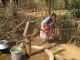 A woman pumping water in rural India in 2007